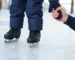 Kind auf Kinder-Schlittschuhen auf der Eisbahn, ein Elternteil hält die Hand – Kinder-Schlittschuhe kaufen